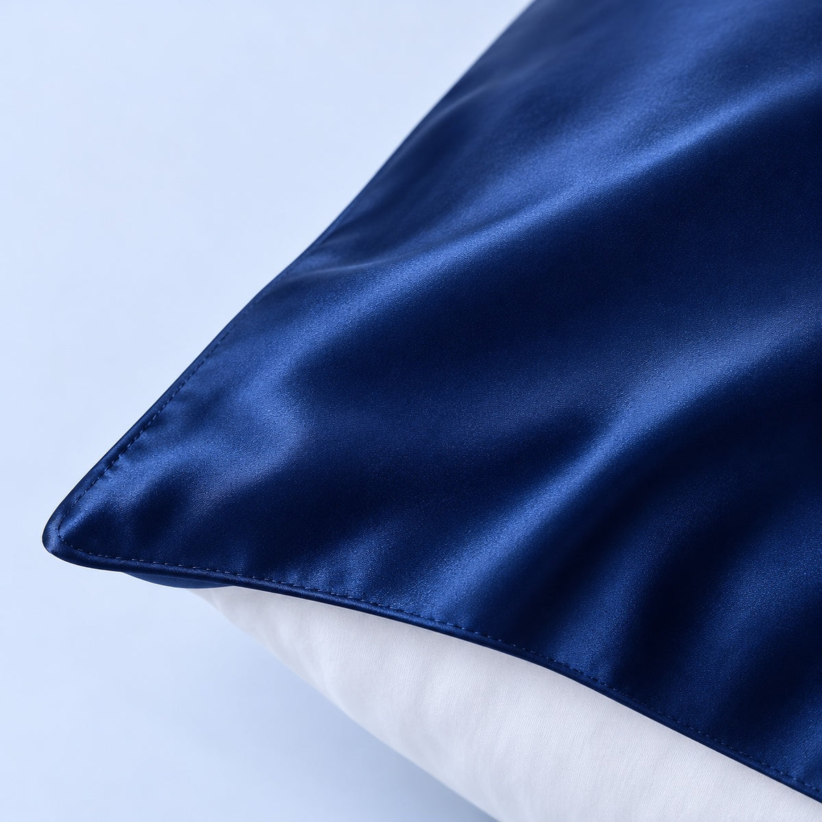 Détail de la texture et de la couture de la taie en soie bleu nuit