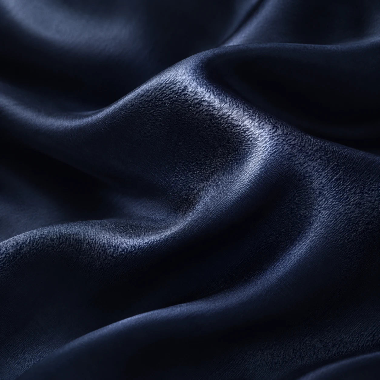 Plis et reflets du tissu en soie bleu nuit